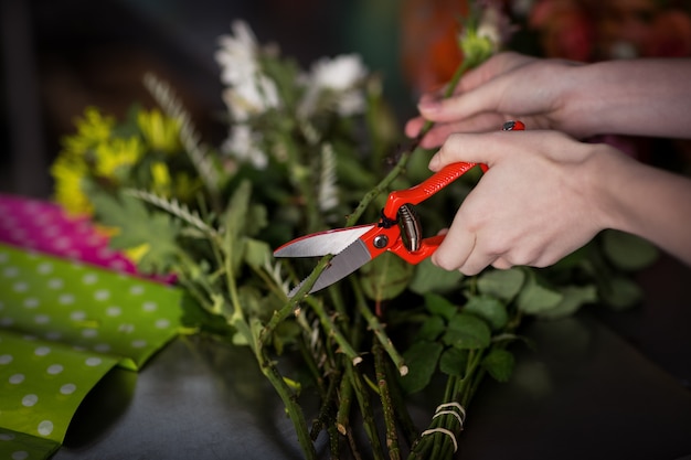 Hand of female florist preparing flower bouquet