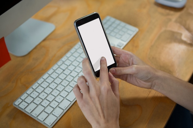 Hand of female graphic designer using mobile phone