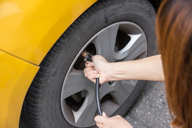 Foto mano che riempie l'aria in un pneumatico per auto