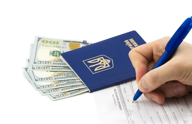 Hand filling visa paperwork with passport and money