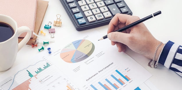 Hand of financial manager taking notes when working on report