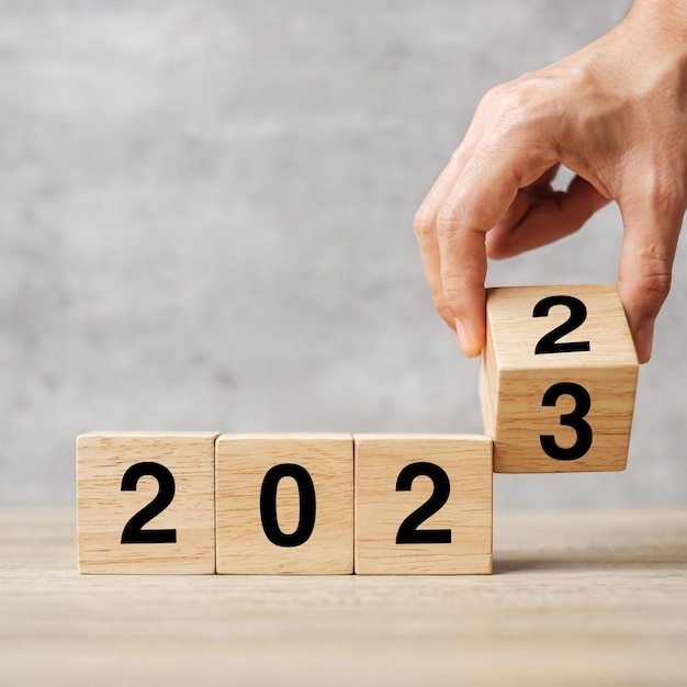 테이블 해결 전략 계획 목표 동기 재부팅 비즈니스 및 새해 휴일 개념에 있는 2022년에서 2023년까지의 텍스트를 손으로 뒤집기