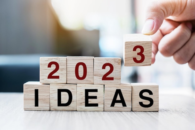 Hand flipping block 2022 tot 2023 IDEE tekst op tafel doel resolutie strategie plan motivatie reboot business en nieuwjaar vakantie concepten