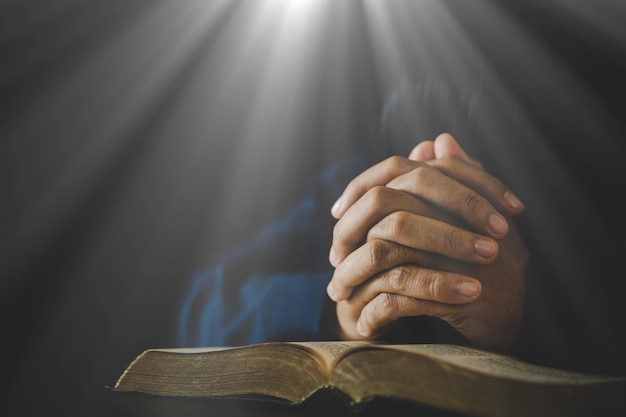 信仰の精神性と宗教の教会の概念の聖書の本に神への祈りで折り畳まれた手は、聖書の崇拝と朝のキリスト教のカトリックの女性の手で聖書に祈る宗教女性人