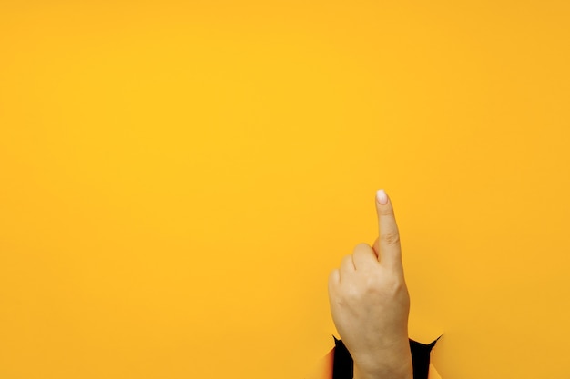 Указательный палец руки, указывающий направление, изолированные на желтом фоне.