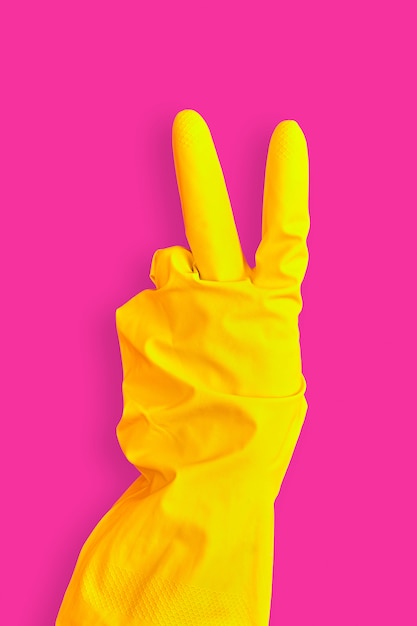 Hand gesture peace in yellow rubber glove