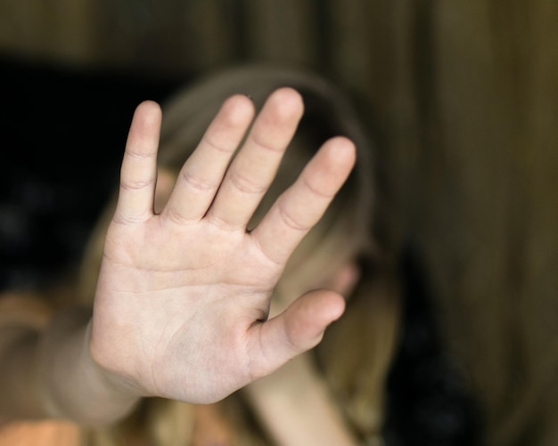 A hand gesture signifying a stop The girl's palm extended forward