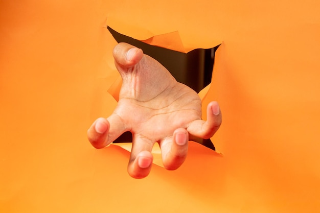 Photo hand gesture on torn orange paper background
