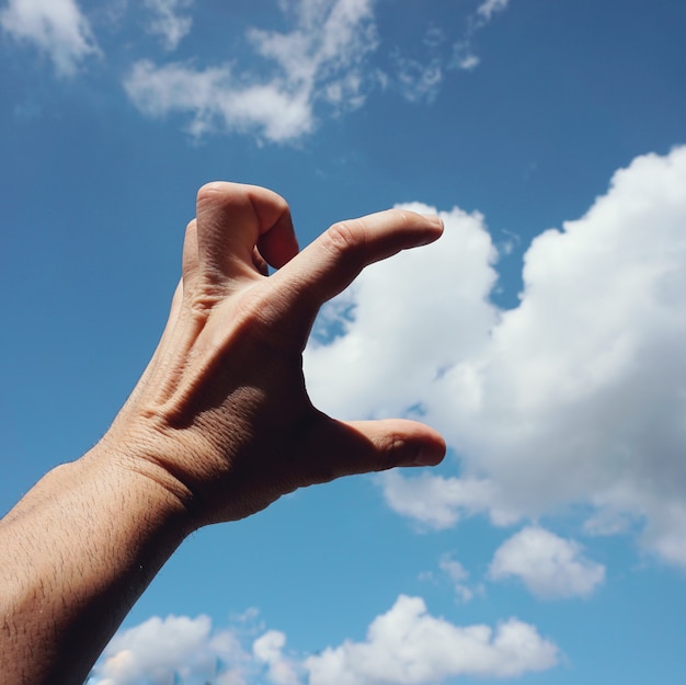 hand gesturing in the blue sky