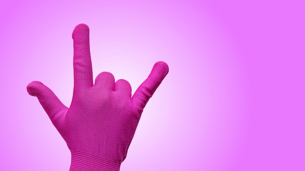 Hand Gesturing in Pink Glove as I Love You Isolated on Gradient Pink Background