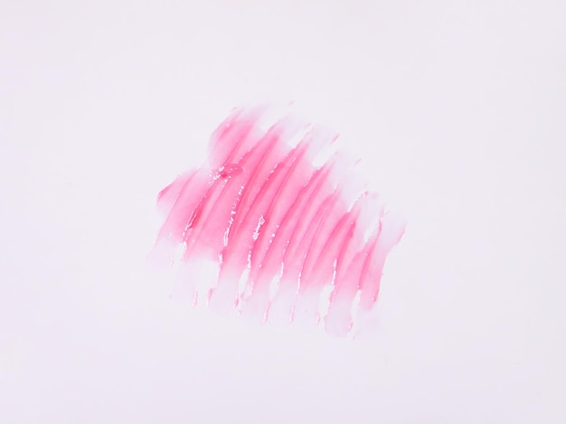 Hand getekende vorm van het hart. Steekproef van roze lipgloss op een witte achtergrond.