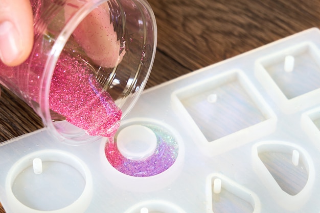 Foto hand gieten glitter in een plastic mal