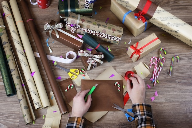 Hand gift wrapping paper for the holiday Christmas ribbon and bows