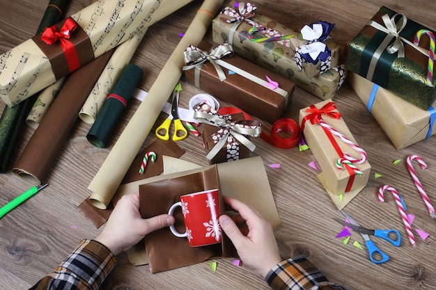 Hand gift wrapping paper for the holiday Christmas ribbon and bows