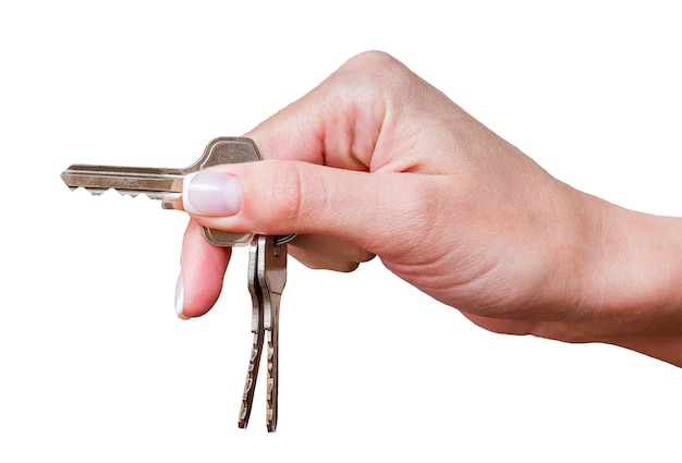 Hand of girl with keys from home or car on white