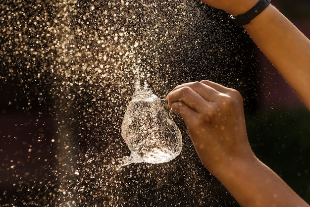 Hand of girl with water splash on black background