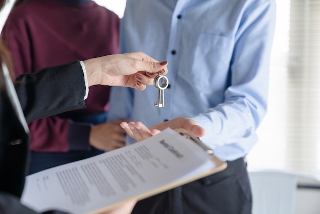 hand giving keys and documents to a couple