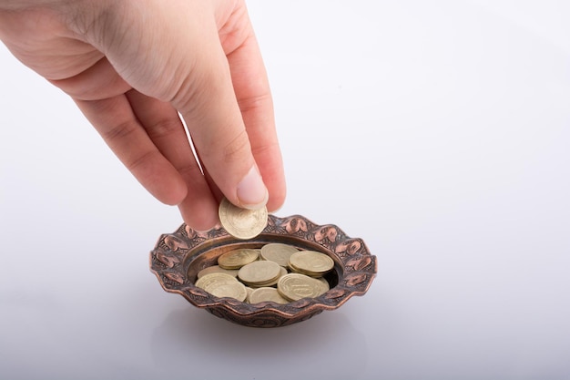 Photo hand giving money to a bowl