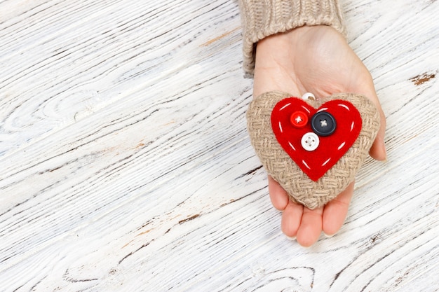 Hand giving textile heart