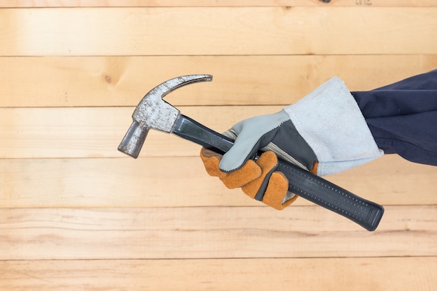 Hand in glove holding hammer