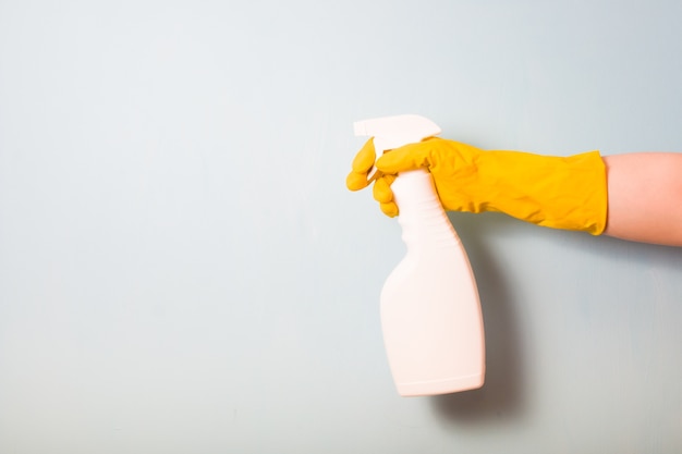 hand in a glove holds a spray bottle