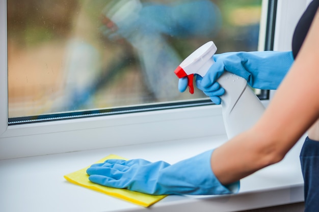 Hand in glove washes a window