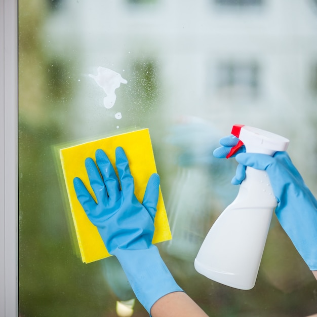 Hand in glove washes a window