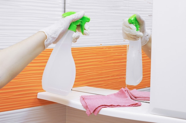 Hand in glove washing a mirror