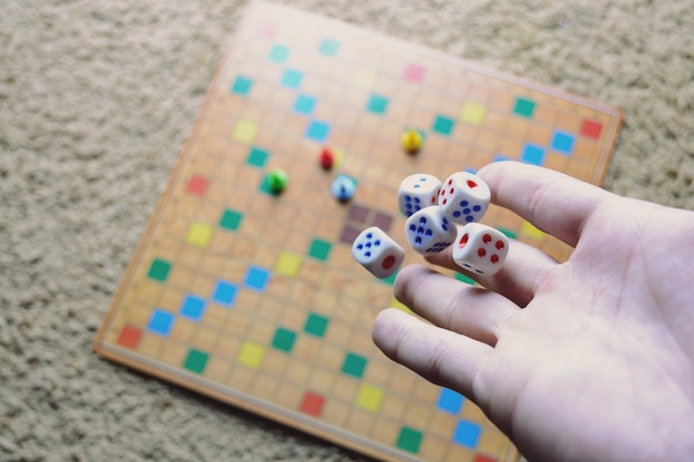 Hand gooien witte dobbelstenen achtergrond kleurrijke wazig bordspel