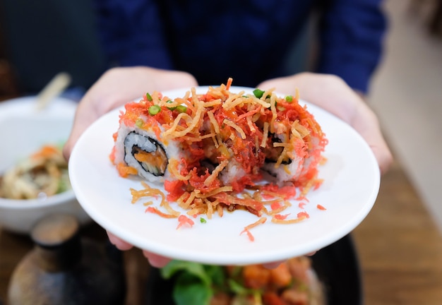 hand greep gerecht van gerolde sushi in de keuken