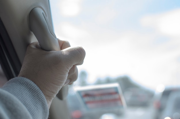 Hand gripping handle in a passenger room of a car