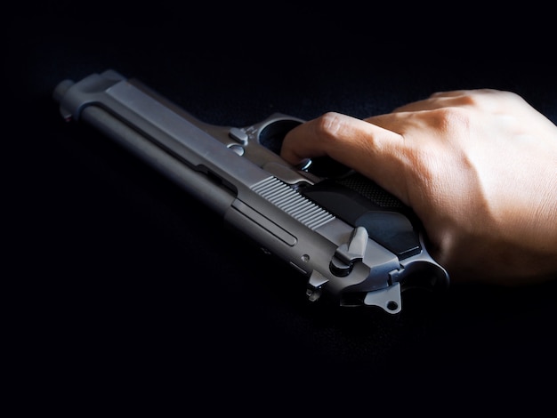 hand and gun and pull trigger with finger