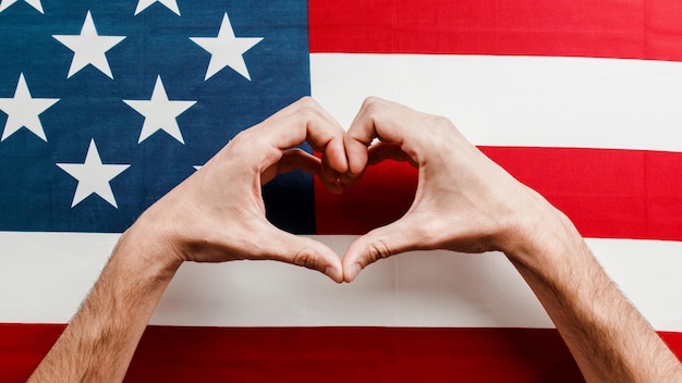 Рука в форме сердца на американском флаге