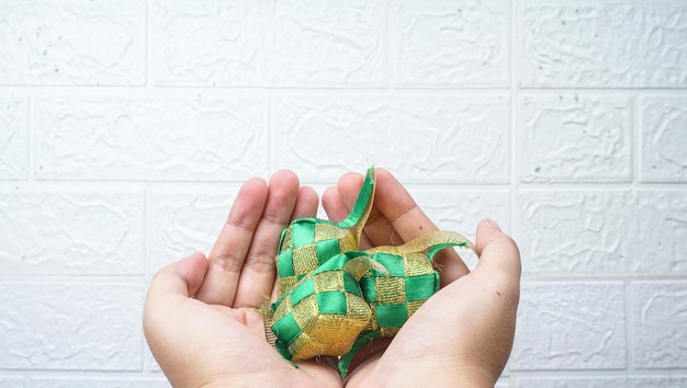 手で開催されたイスラム教徒 Ketupat 米団子 翻訳 Eid Mubarak 祝福された饗宴