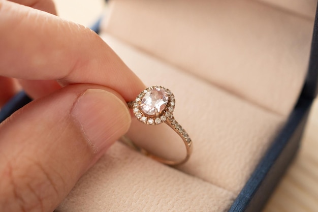 Рука держит красивое ювелирное кольцо с бриллиантом