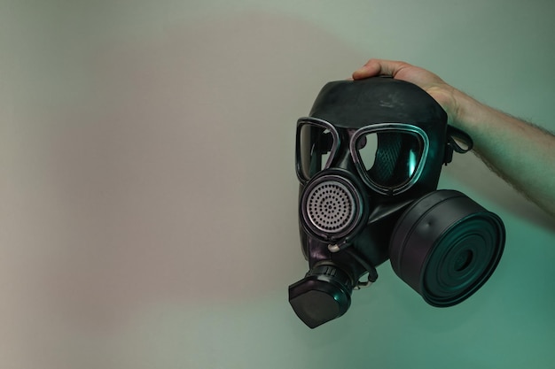 Hand hold black old gas mask in the color light Beautiful old minimal in neon light Minimalism ret