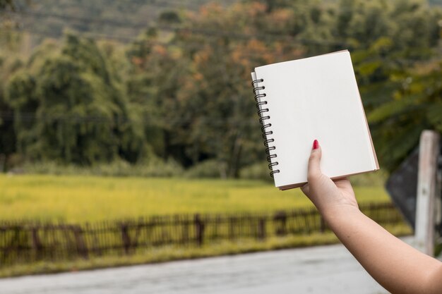 Hand hold blank book on nature