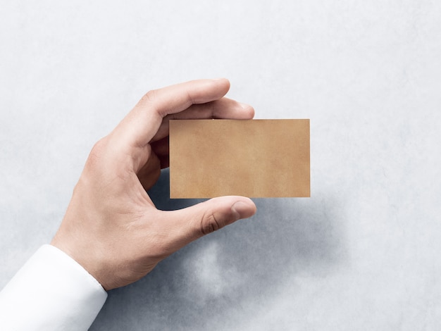 Hand hold blank plain kraft business card design mockup