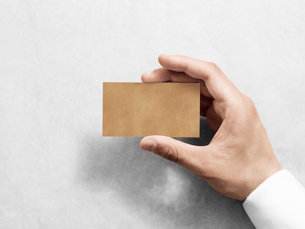 Рука держать пустой простой дизайн визитной карточки крафт
