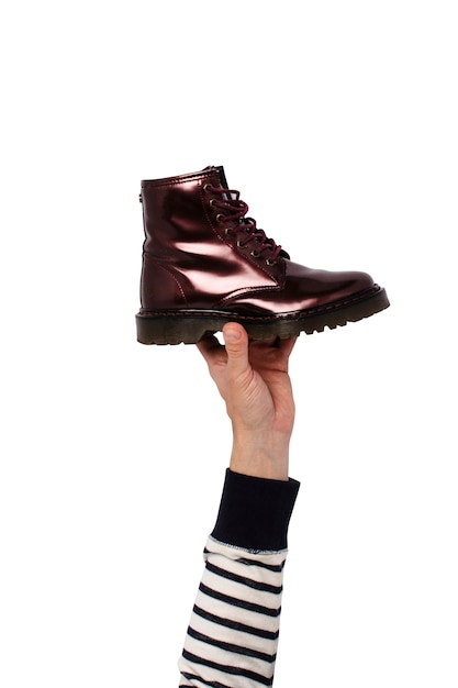 Hand hold a boot on an isolated. Concept of choice of shoes, shopping, shoe repair
