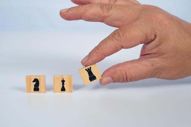 Hand hold chess icon on wood block Success game concept