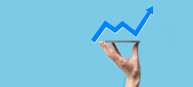 Фото Рука удерживайте рисунок на экране растущего графика, стрелка значка положительного роста. указывая на творческую бизнес-диаграмму с восходящими стрелками. концепция финансового, бизнес-роста.