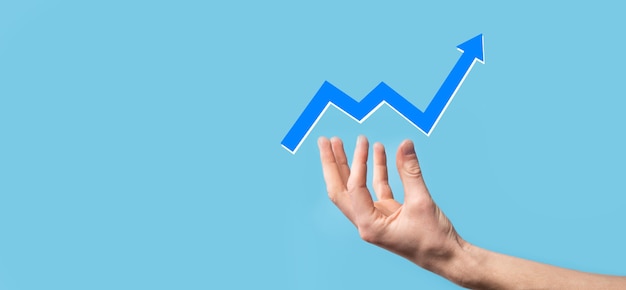 Hand hold drawing on screen growing graph, arrow of positive
growth icon.pointing at creative business chart with upward
arrows.financial, business growth concept.