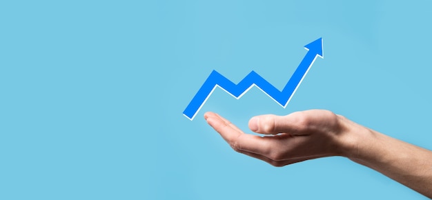 Hand hold drawing on screen growing graph, arrow of positive growth icon.pointing at creative business chart with upward arrows.Financial, business growth concept.