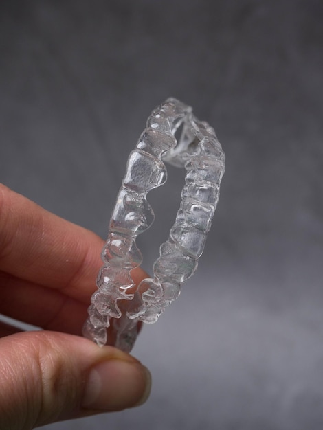 Hand hold invisible aligners plastic braces dentistry retainers to straighten teeth