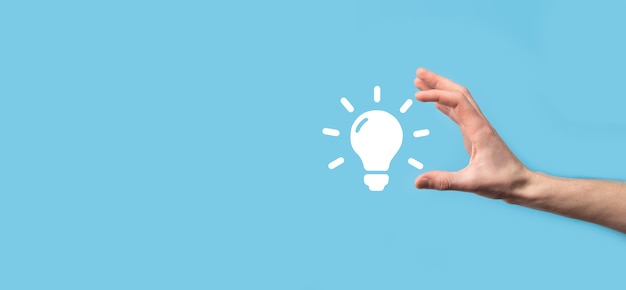 Hand hold light bulb. holds a glowing idea icon in his hand.\
with a place for text.the concept of the business idea.innovation,\
brainstorming, inspiration and solution concepts.