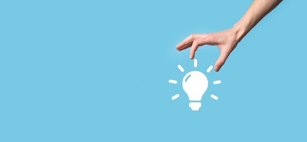 Hand hold light bulb. Holds a glowing idea icon in his hand. With a place for text.The concept of the business idea.Innovation, brainstorming, inspiration and solution concepts.