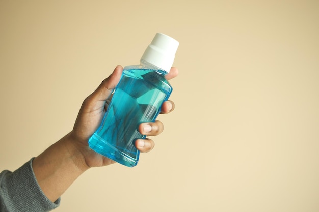 hand hold a mouthwash liquid container