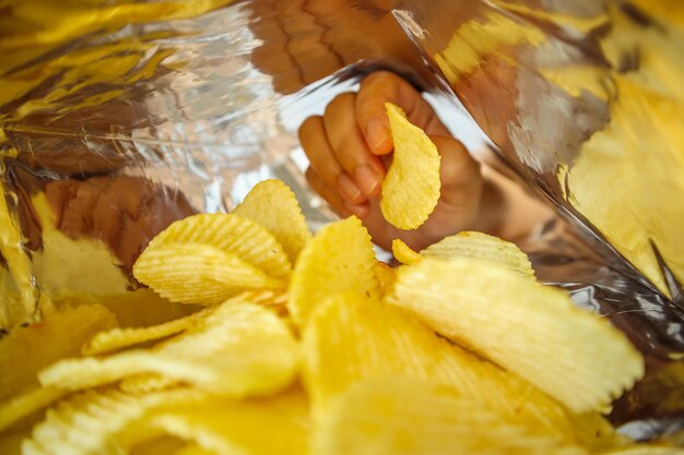 Foto tenere in mano le patatine all'interno del sacchetto di alluminio per snack