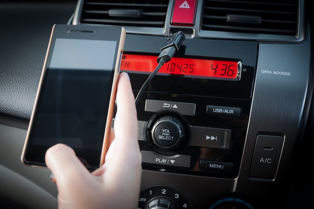 Foto mano tenere smartphone in auto, persone premere il telefono durante la guida